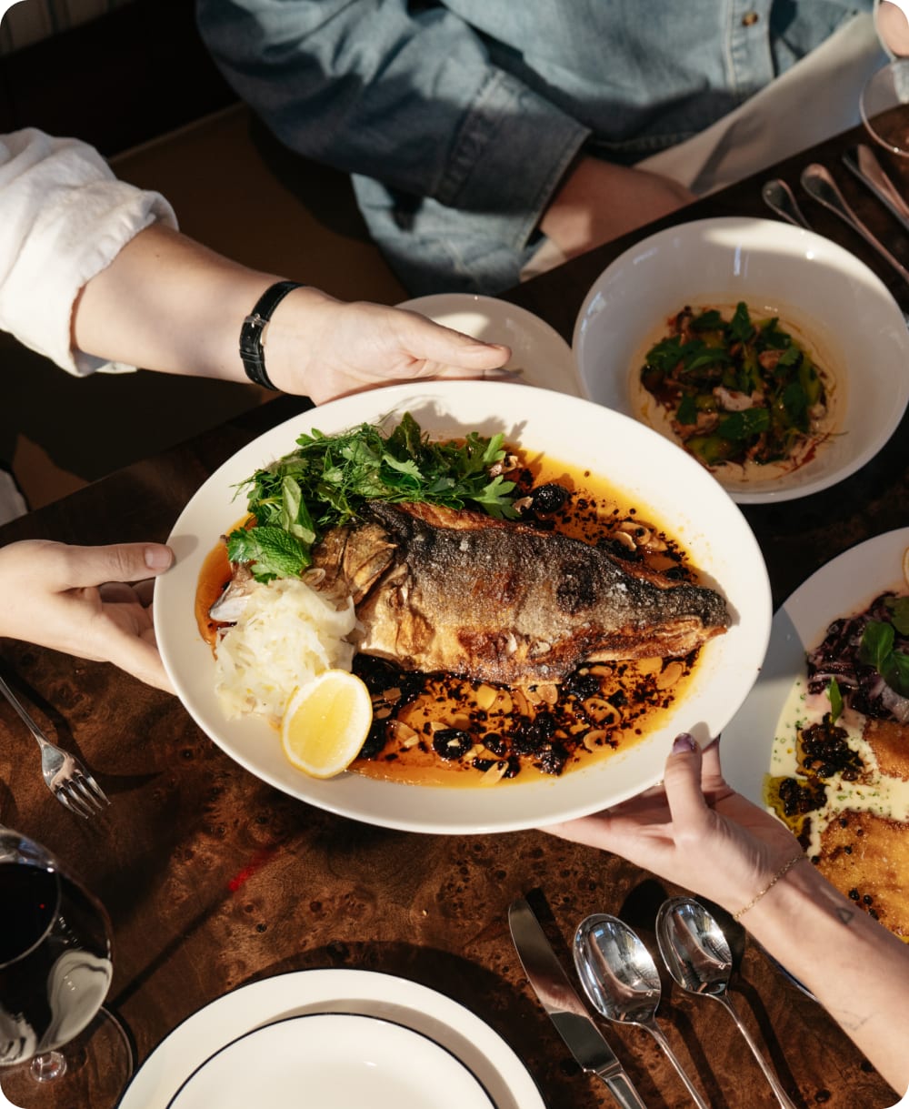 Whole roasted fish served on a white Serving Platter at a gathering