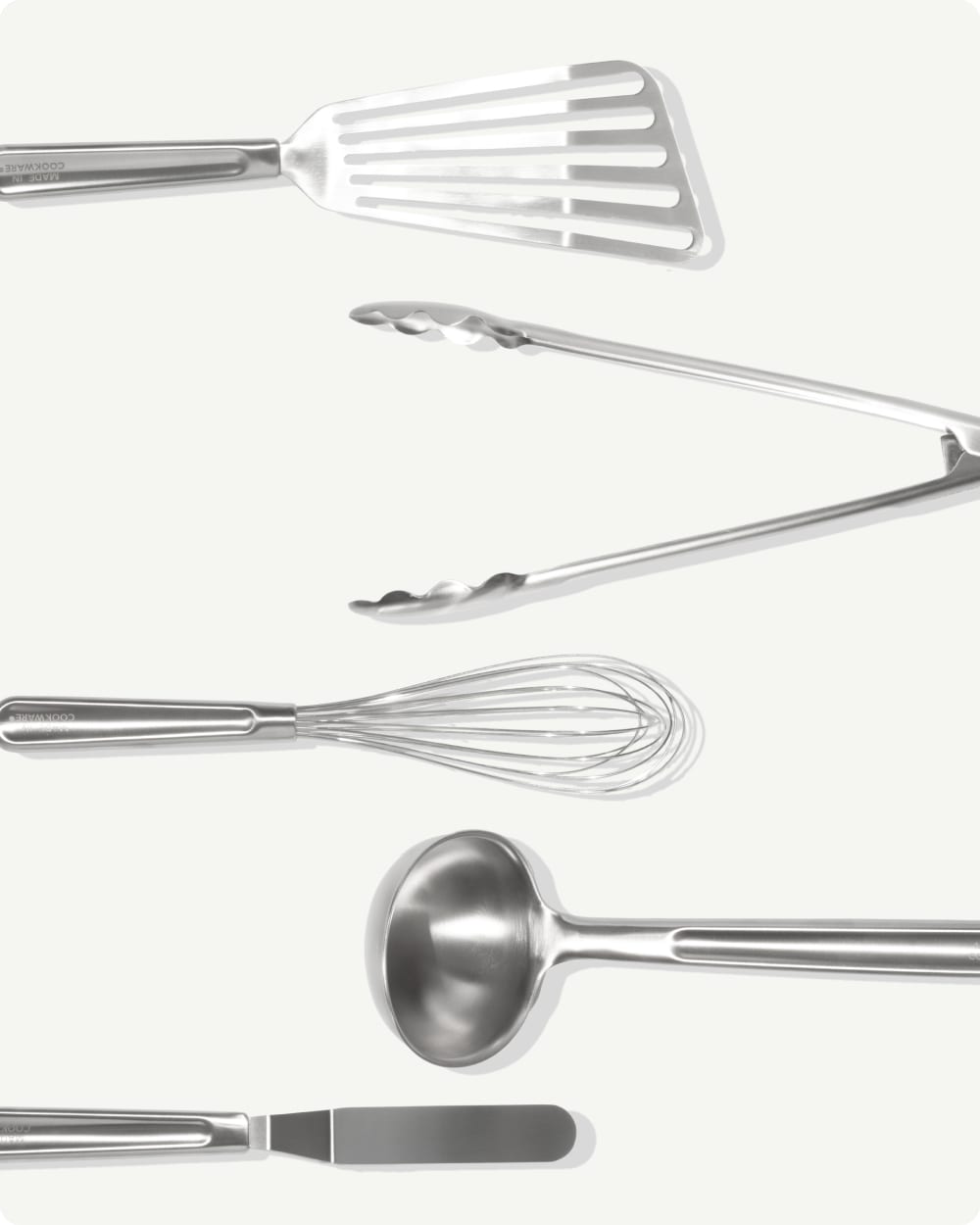 Five stainless steel utensils arranged on a light background