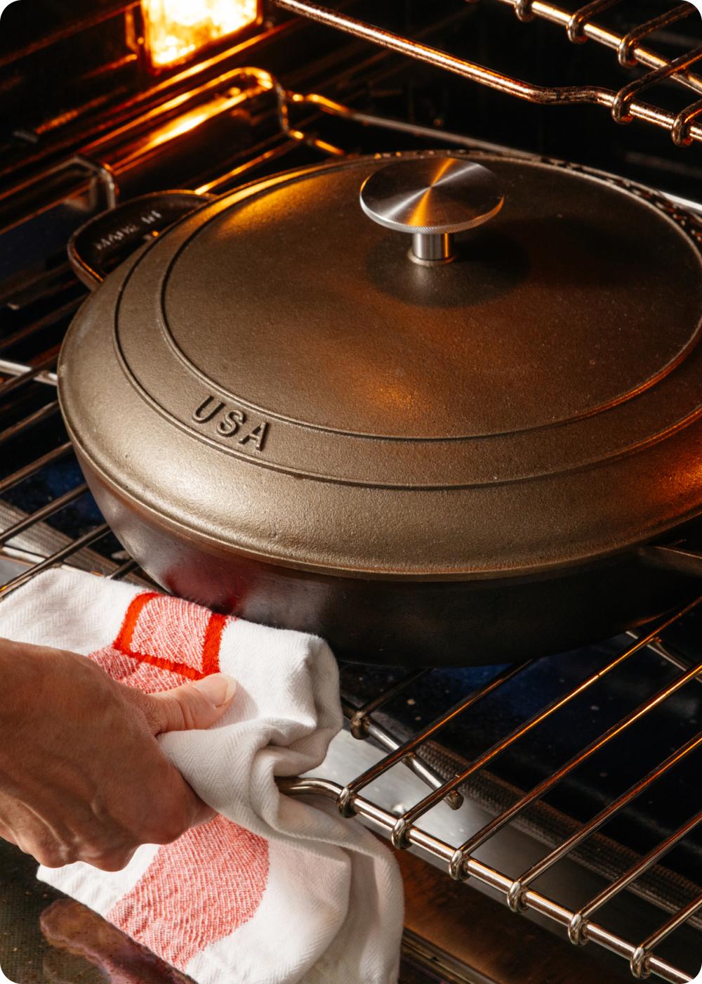 Cast iron braiser with lid resting on an oven rack