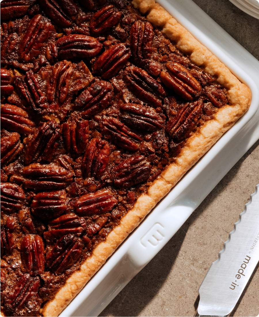 Bourbon pecan slab pie in a Made In baking slab with a Made In knife