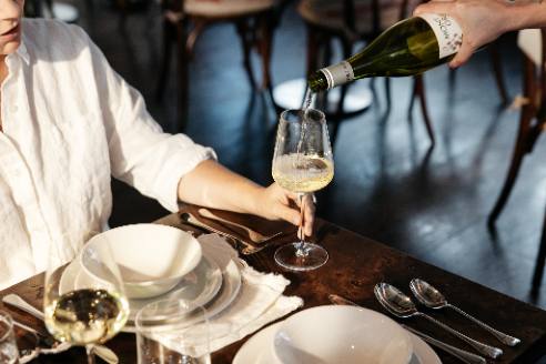 White wine poured into a Crystal White Wine Glass held at the table