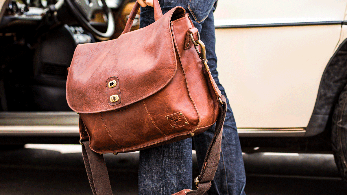 Handcrafted Will Leather Goods messenger bag carried beside a truck