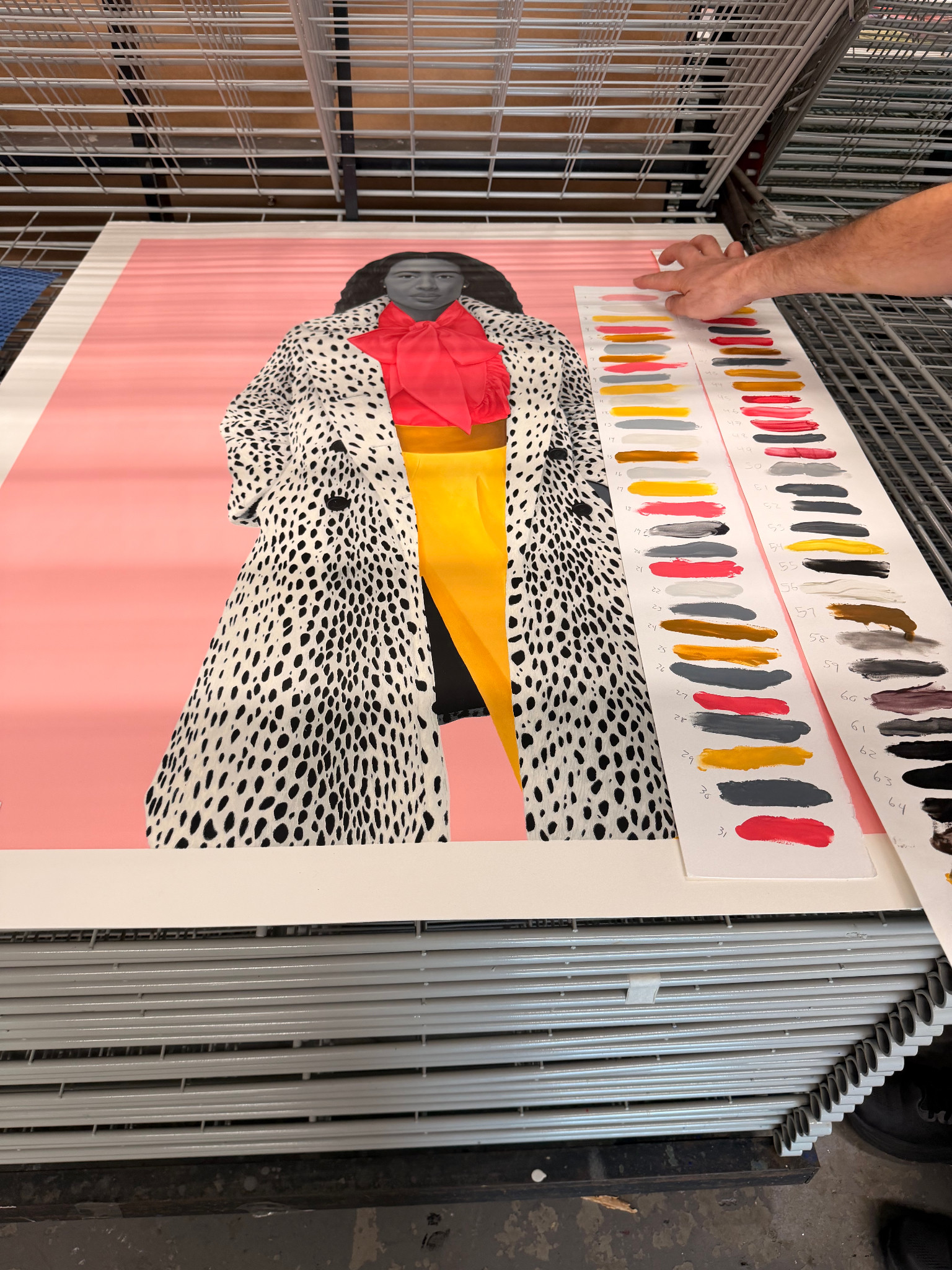 Amy Sherald portrait print on a drying rack: a woman in a spotted coat, red bow blouse and yellow skirt against pink, beside numbered color swatches.