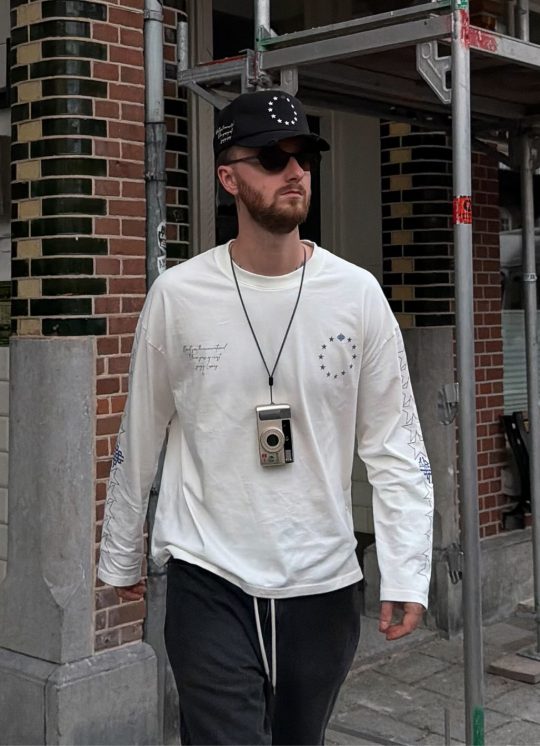 Community member in an off-white graphic long sleeve and cap