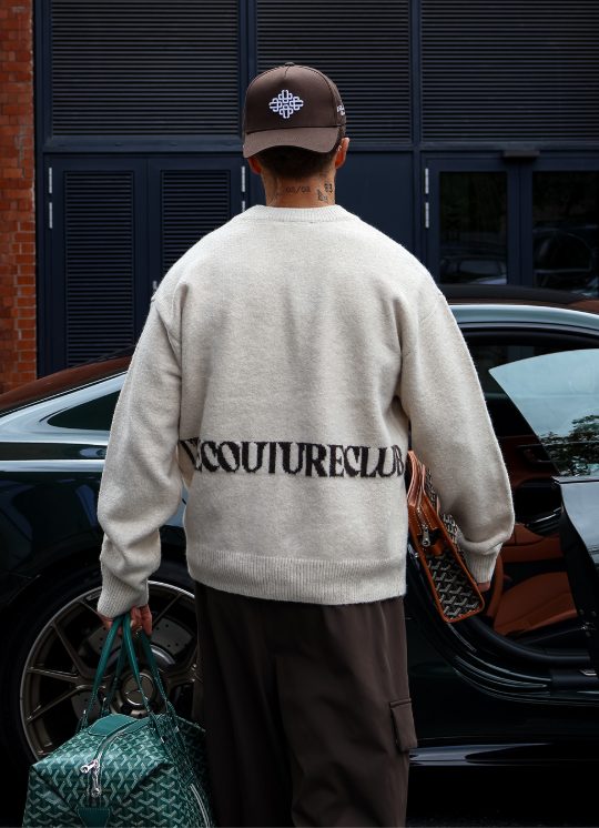 Community member in a The Couture Club logo knit
