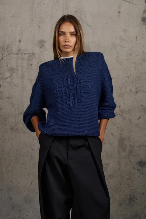 Model in a dark navy emblem loose-knit oversized crew jumper