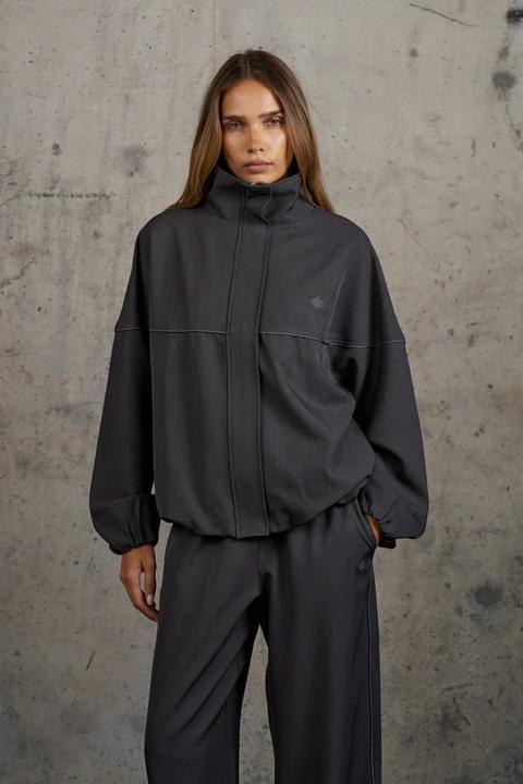 Model in a charcoal balloon-hem funnel-neck wool jacket
