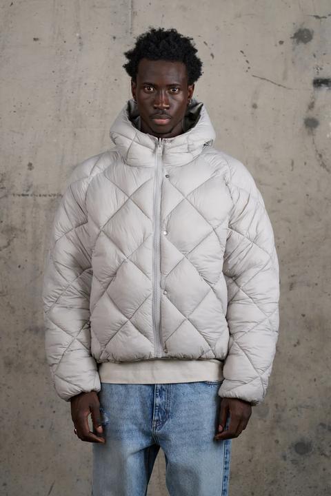 Model in a light grey diamond-quilted reversible puffer coat