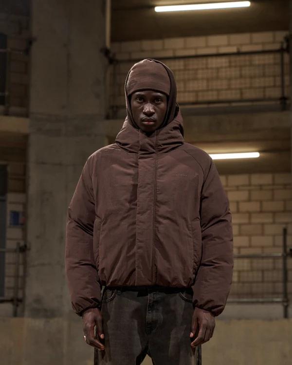 Model in a chocolate brown hooded puffer jacket