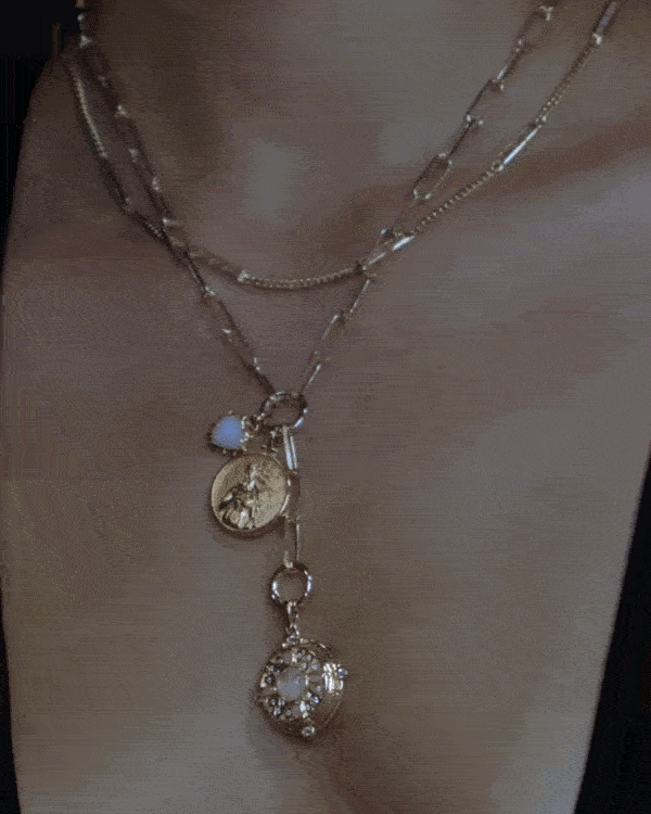 Hands adding a charm to a Collector necklace