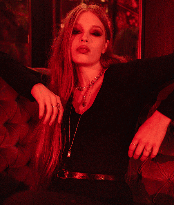 Model in red light wearing Nocturne necklaces at the Awe seance