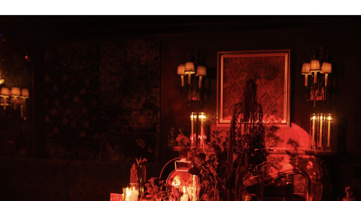 Candlelit seance table set with flowers and crystal