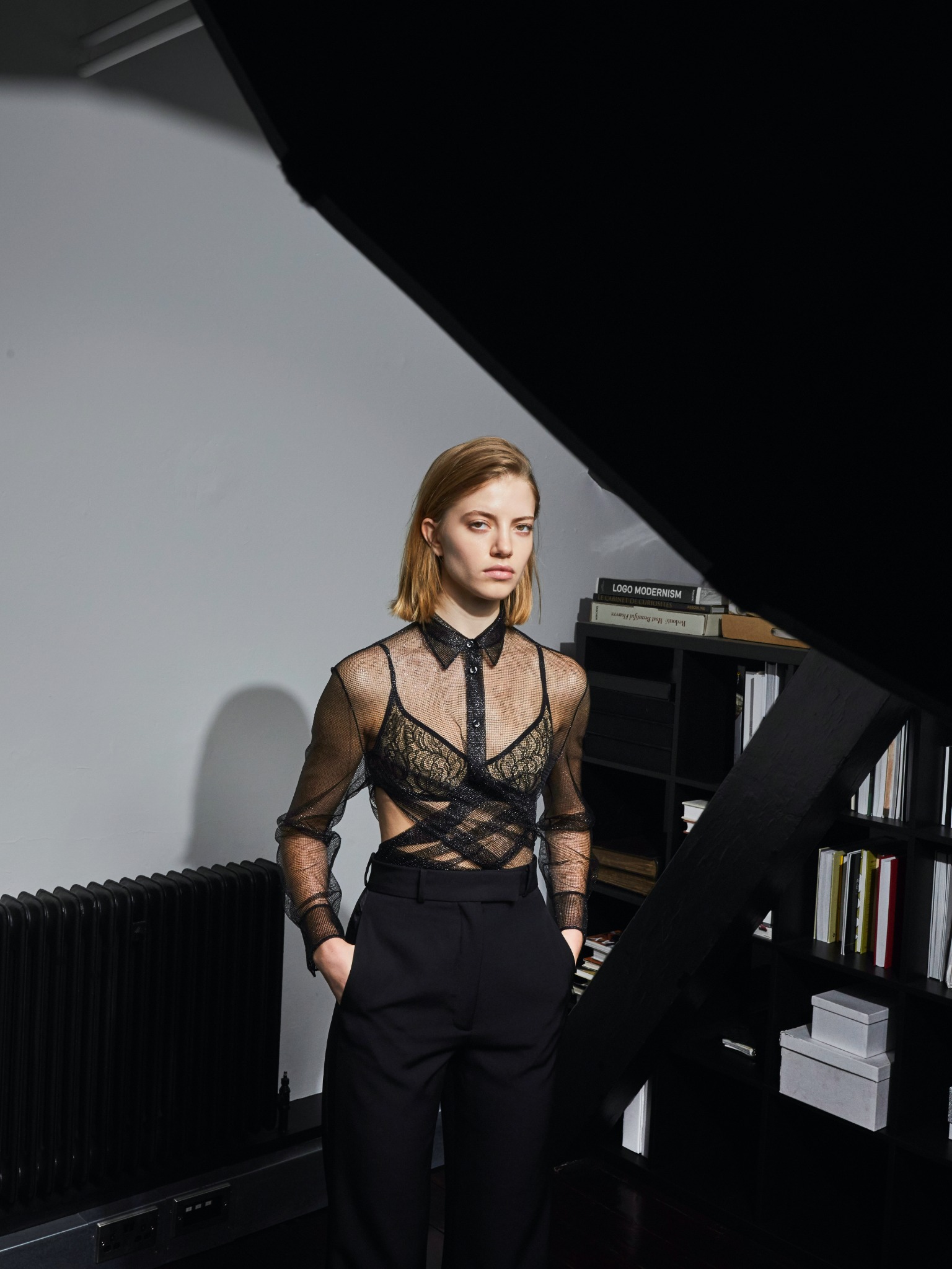 CHUCHOTER in black metallic mesh worn over a lace bralette with tailored trousers