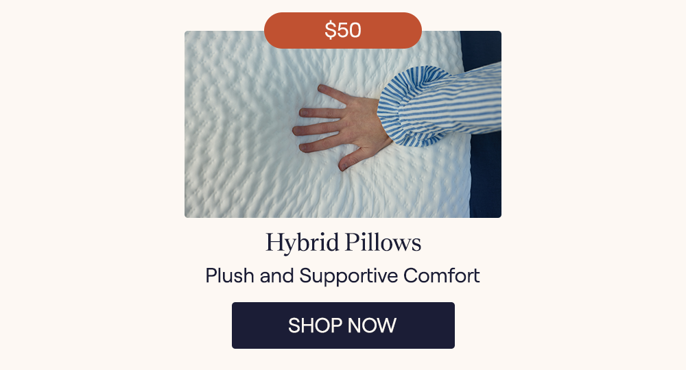 A woman's hand pressing down on a Hybrid Pillow highlighting how plush it is
