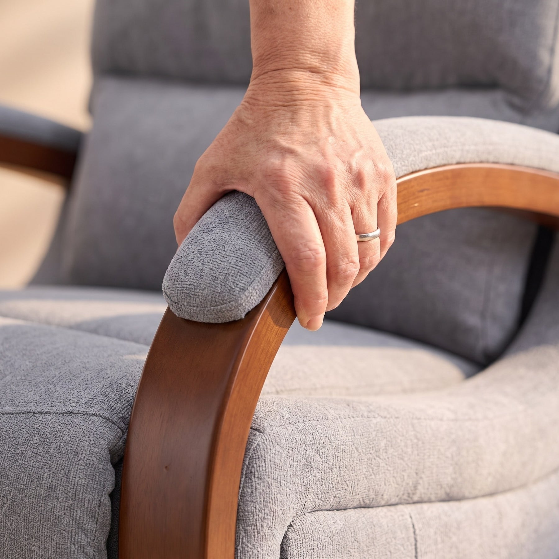 Hand gripping the curved solid wood armrest