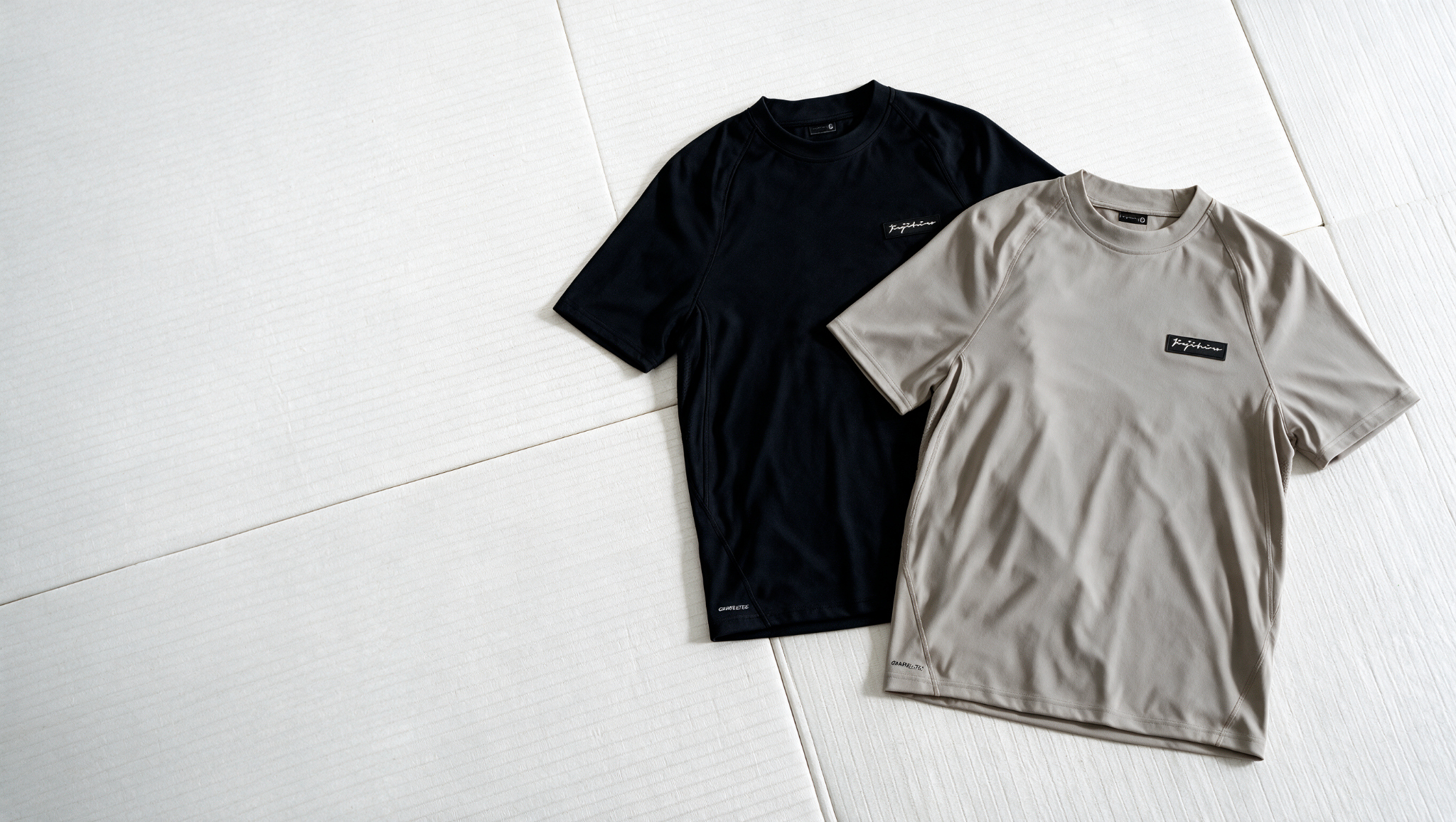 Black and Sand Pro Grapple Tees on white tatami mats