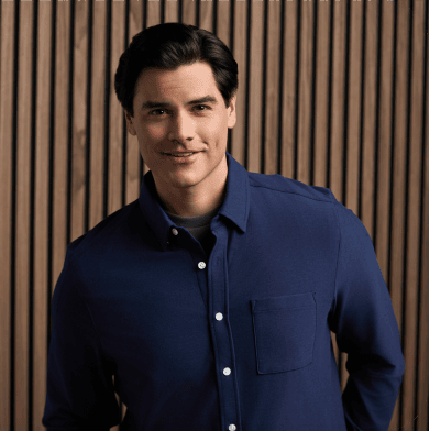 Man with dark hair in dark blue button down shirt.