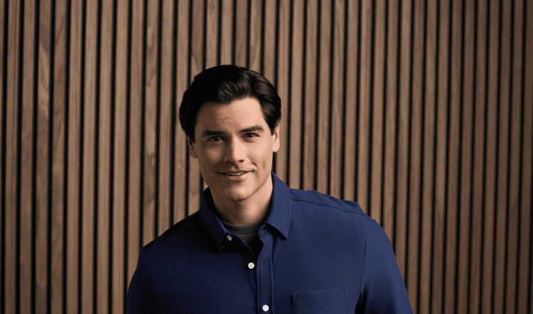 Man with dark hair in dark blue button down shirt.