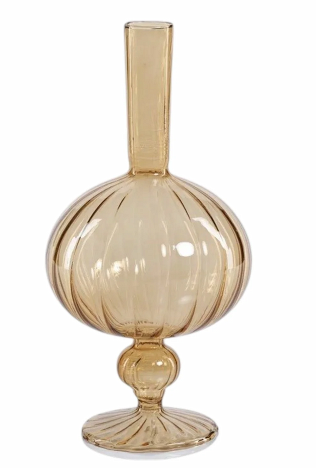 Amber glass bud vase with a rounded ribbed body, slender neck, and decorative pedestal base. Fearrington Village.