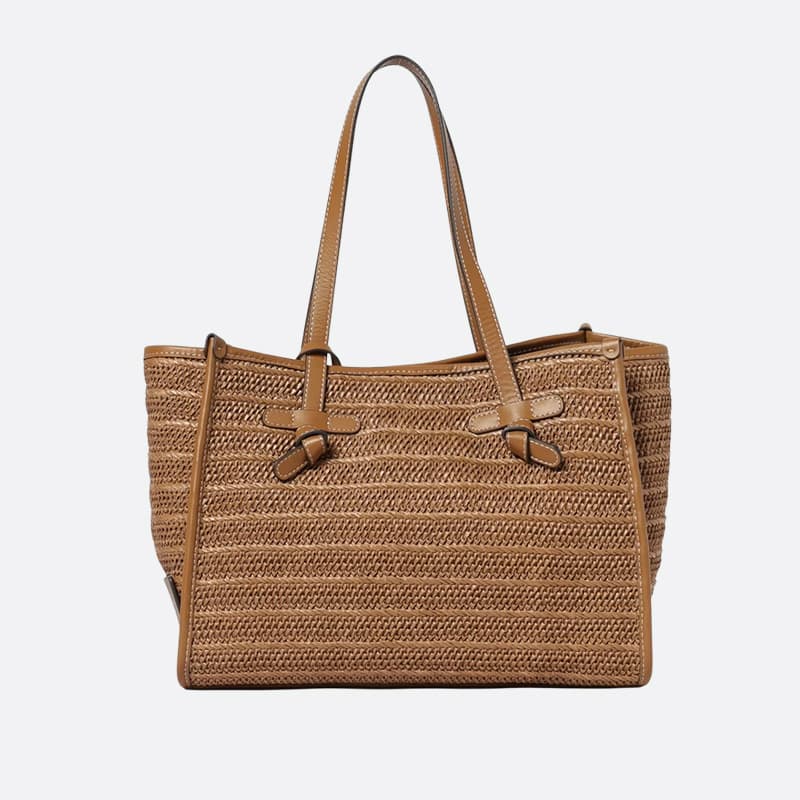 Woven tan tote bag with coordinating leather trim, long handles, contrast stitching, and knotted strap details. Fearrington Village.