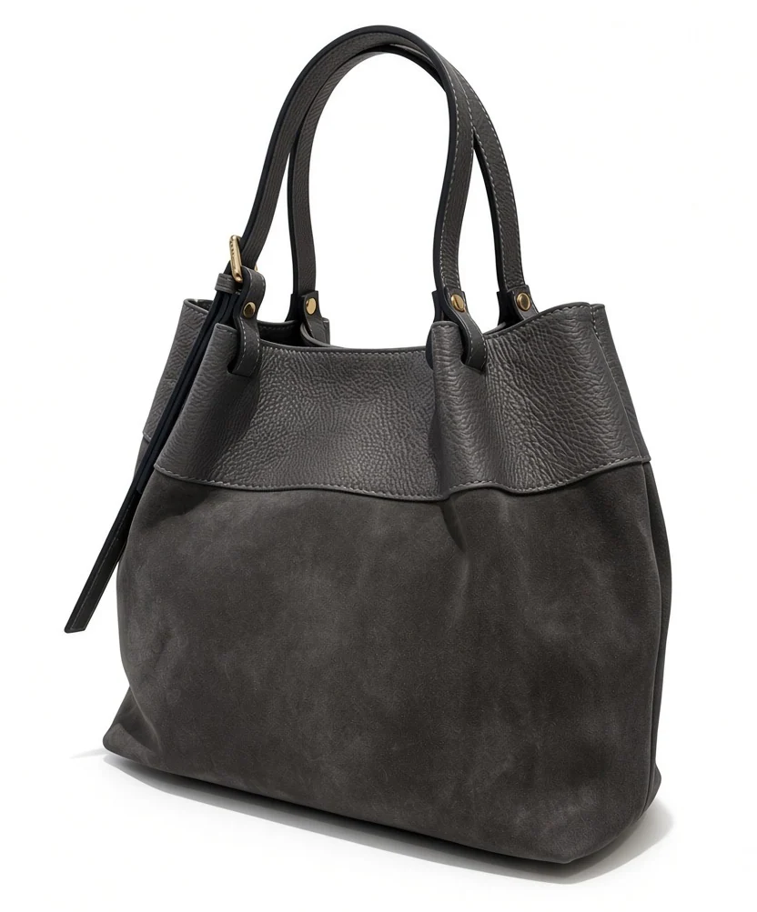 Charcoal gray suede tote handbag with textured leather trim, double leather handles, gold-tone hardware, and a relaxed silhouette. Fearrington Village.