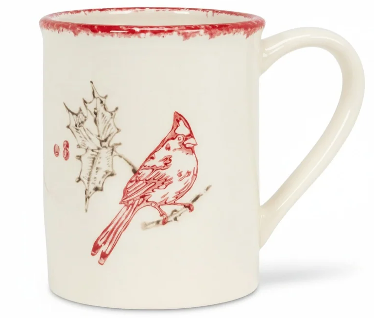 Cream ceramic mug featuring a red cardinal perched beside holly leaves and berries, finished with a rustic red rim. Fearrington Village.