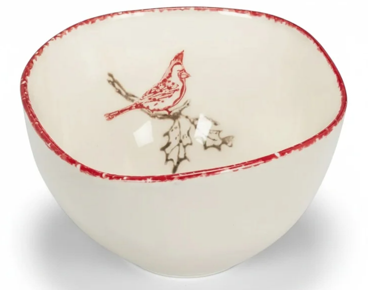 Cream ceramic bowl featuring a red cardinal perched on a holly branch inside, finished with a rustic red rim. Fearrington Village.