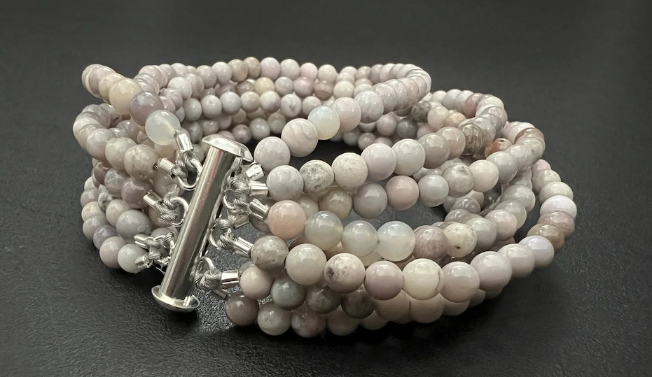 Multi-strand beaded bracelet featuring soft gray, lavender, and pale pink gemstone beads with a polished silver clasp. Fearrington Village.