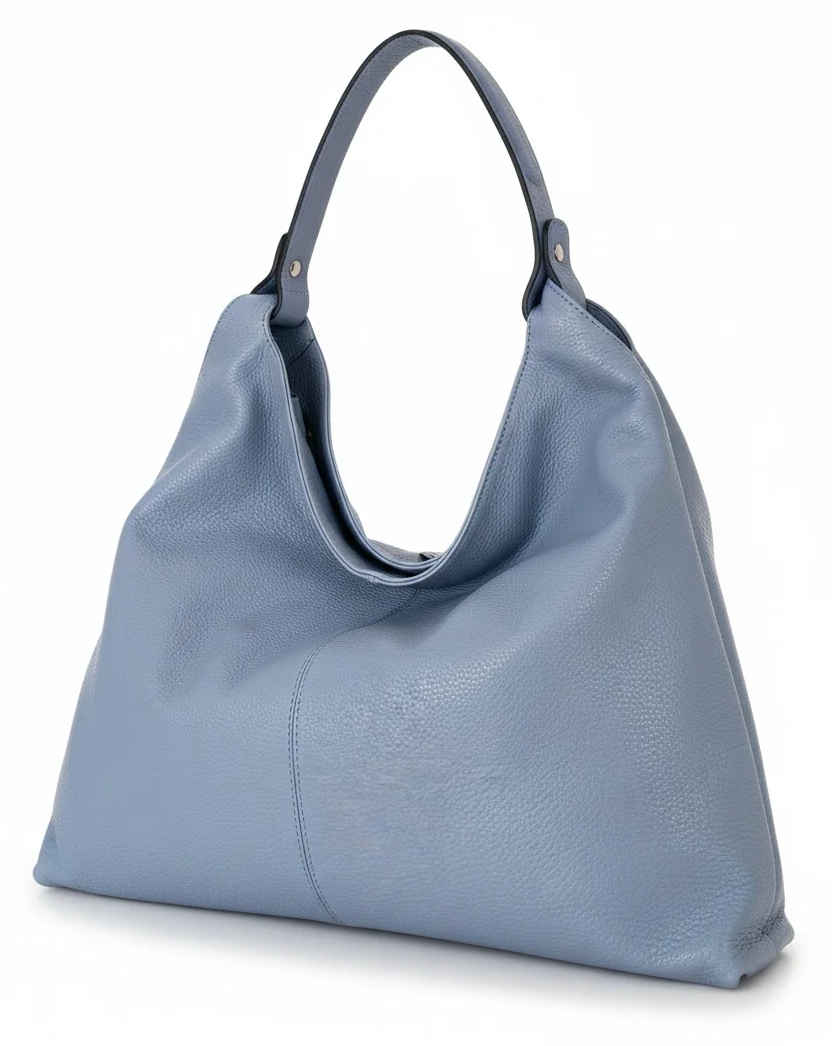 Soft powder blue pebbled leather hobo handbag with a relaxed silhouette, single shoulder strap, and gently draped opening. Fearrington Village.