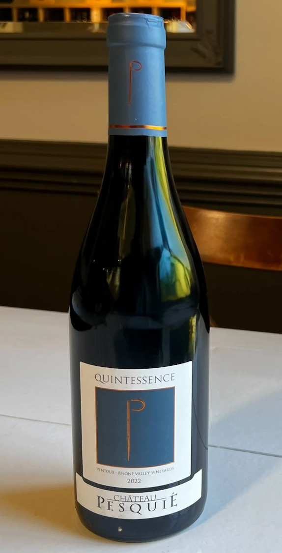 Bottle of 2022 Château Pesquié Quintessence Ventoux red wine on a white table. Fearrington Village.