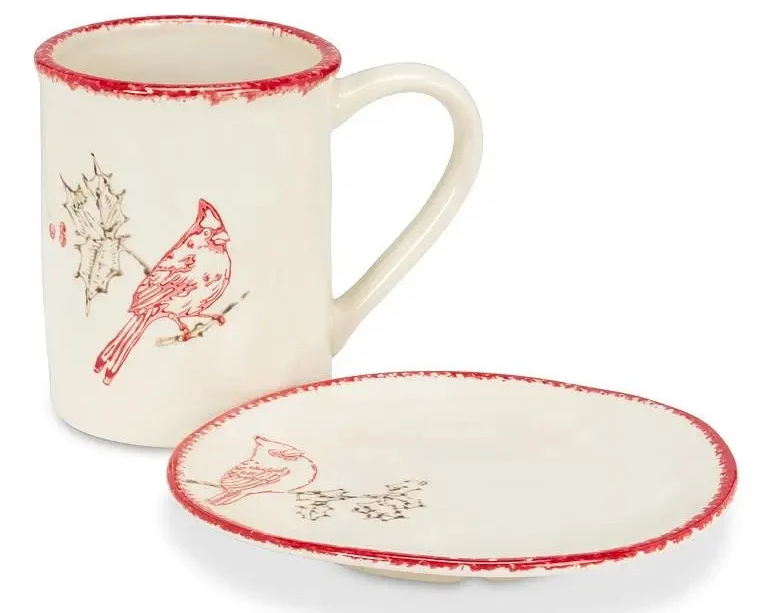 Cream ceramic mug and matching oval plate featuring red cardinal illustrations and rustic red rims. Fearrington Village.