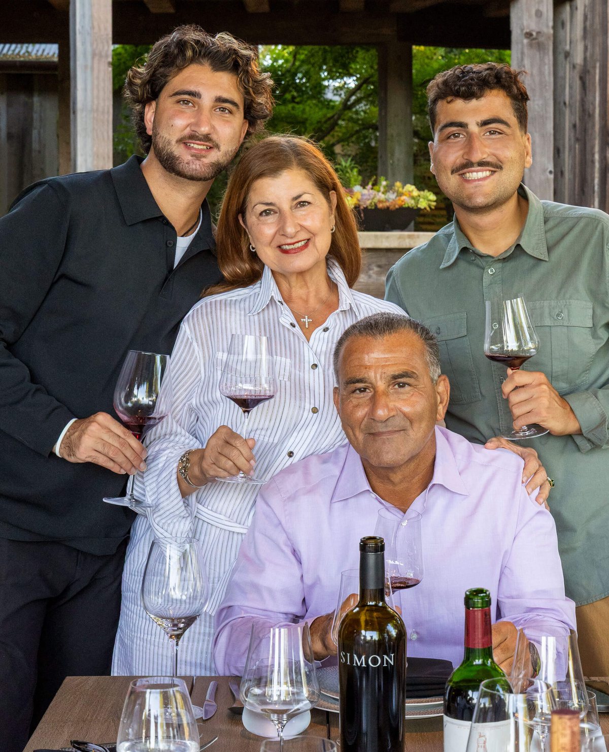 The Simon family at the table with a bottle of Simon Family Estate