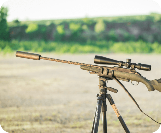 Silencer Shop suppressor mounted on a scoped rifle and shooting tripod outdoors, ready for cleaning and maintenance before opening day.