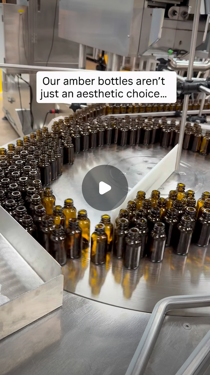 [A screenshot shows a tray of amber glass bottles on an assembly line. Click the image to watch a video of CBDistillery's tinctures being made.]