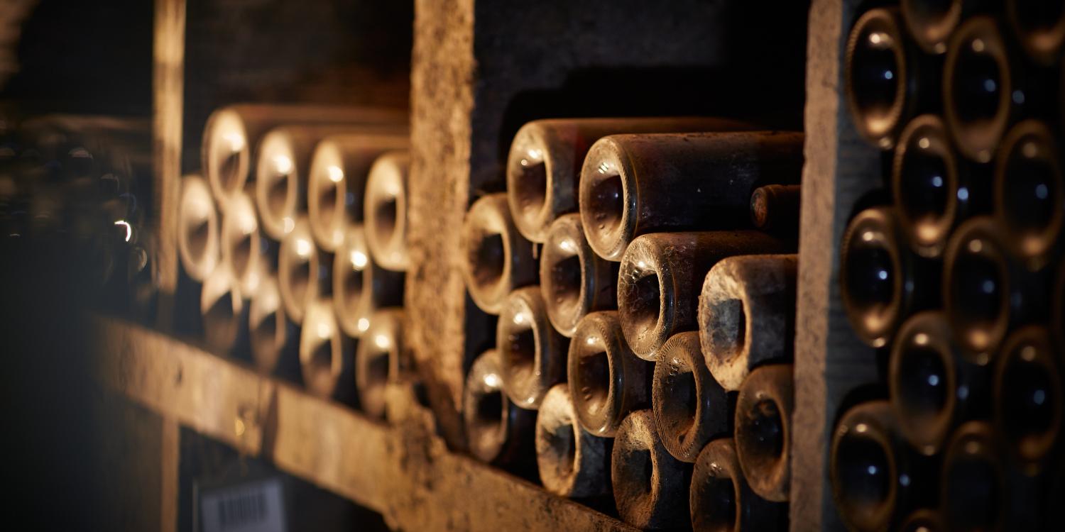 Old wine bottles resting in a cellar