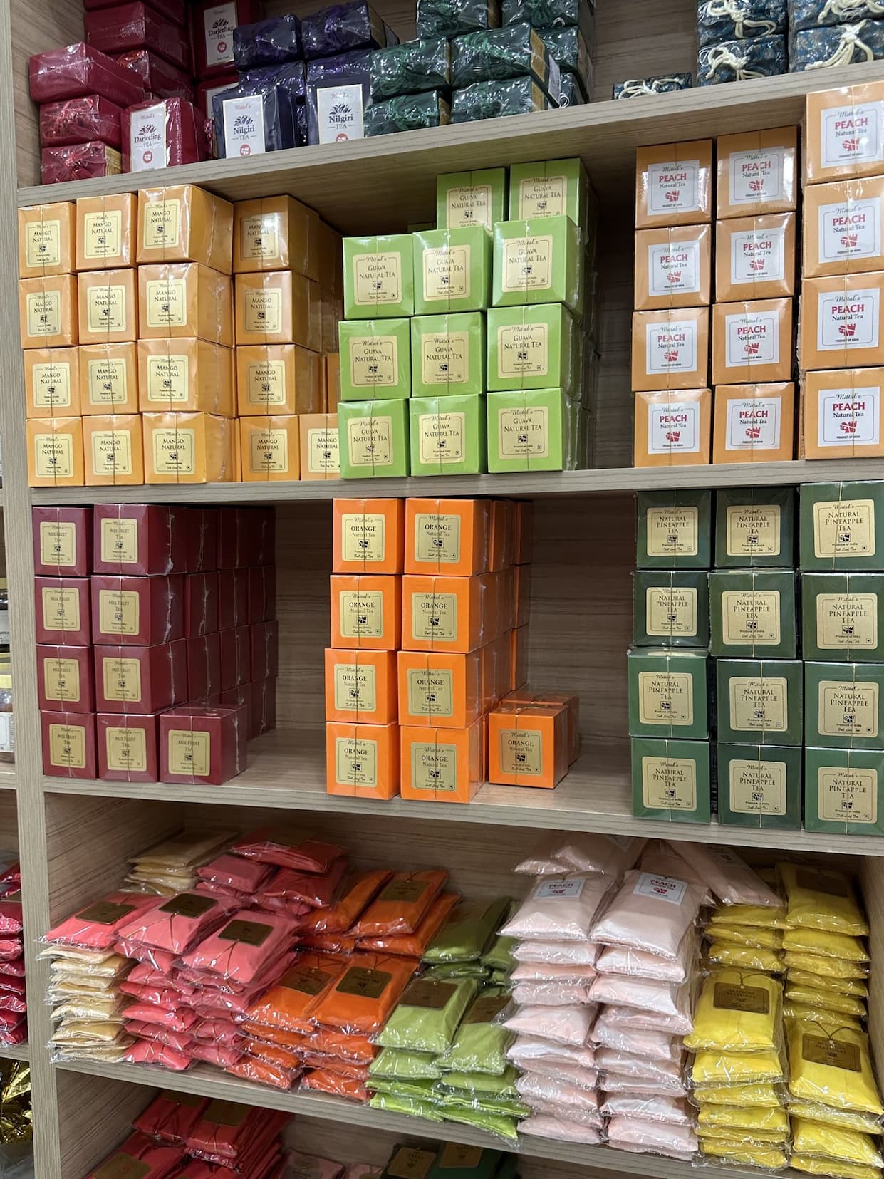 Shop shelves stacked with colorful boxes and packets of tea