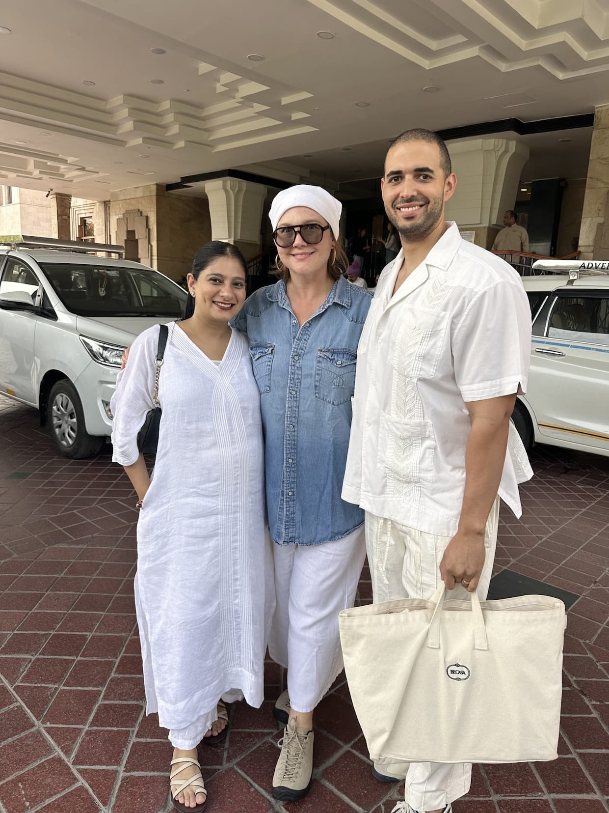 Emily and two companions outside a hotel, one holding a BECASA tote