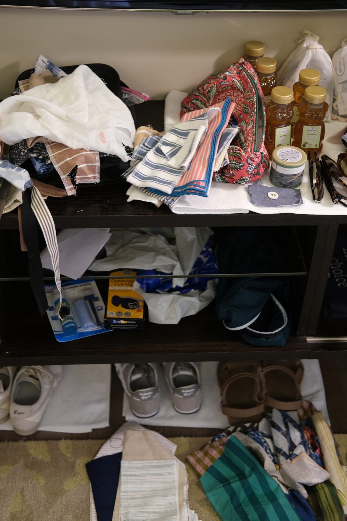 Fabric samples, swatches, and bottles of Tupelo honey on a hotel room shelf