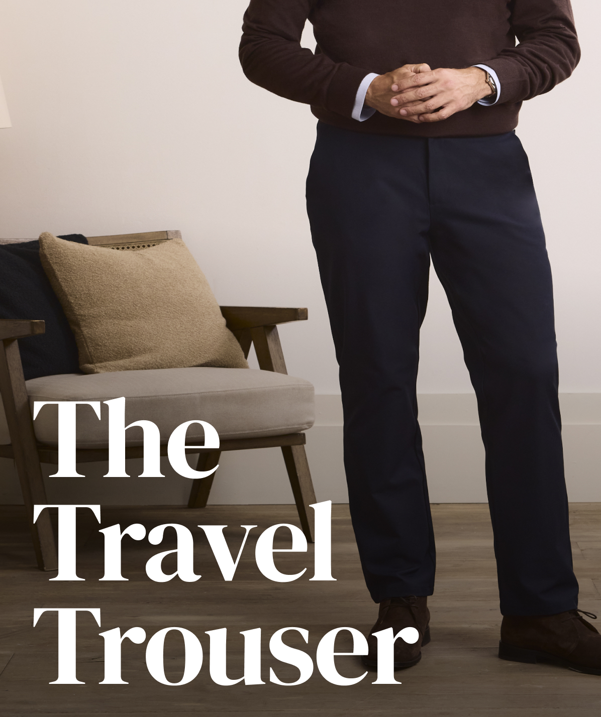man in navy travel trouser and brown quarter zip