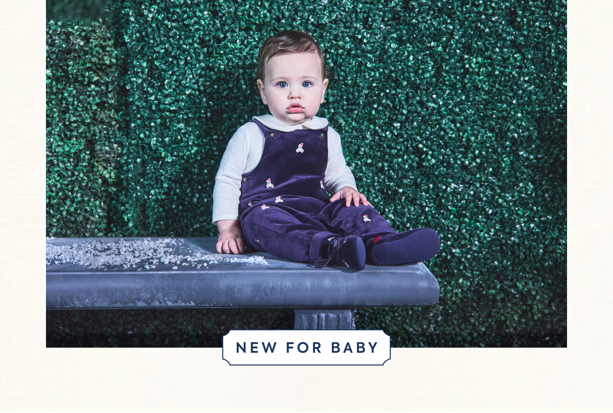 Baby sitting on a bench wearing navy velvet snowman overalls - NEW FOR BABY