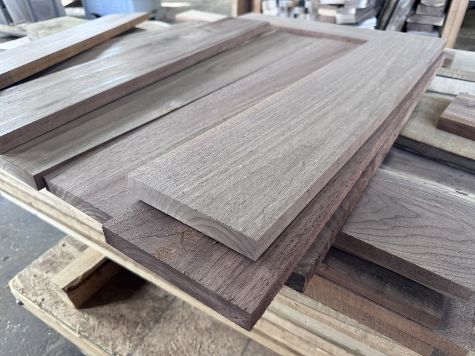 Black Walnut boards laid side by side while a five-pack is sorted by hand