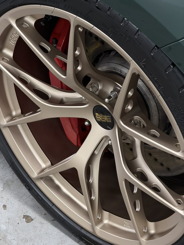 BBS wheel spokes and a red brake caliper on a green BMW M3