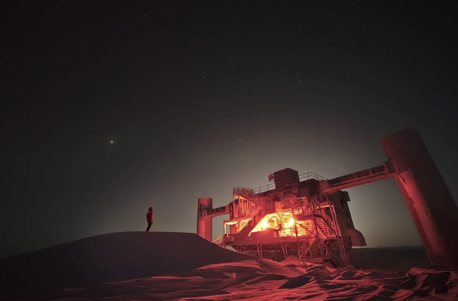 The IceCube observatory at night, lit up in red light