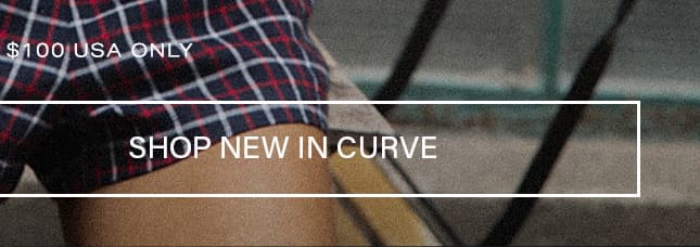 Dark navy and red plaid shorts with overlay text reading $100 USA ONLY and SHOP NEW IN CURVE promoting a new plus size fashion collection.