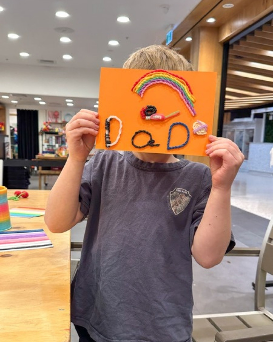 A child's handmade greeting card spelling DAD in colourful reusable wax sticks