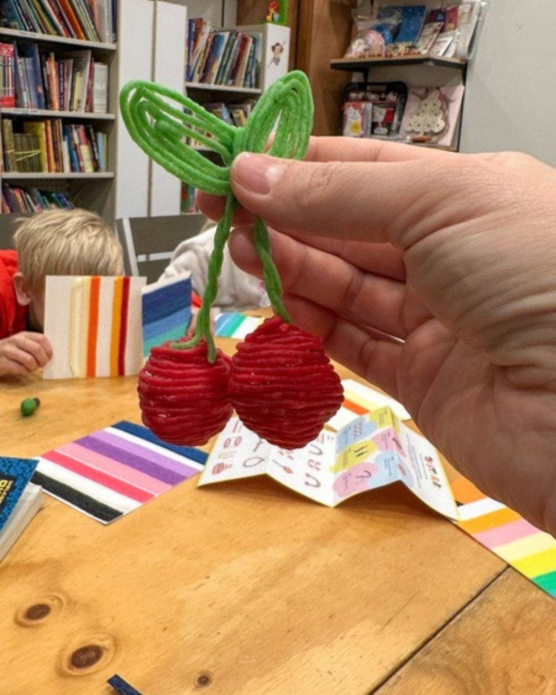 Three-dimensional cherries made from foil wrapped in red reusable wax sticks at the Twisty Kids workshop