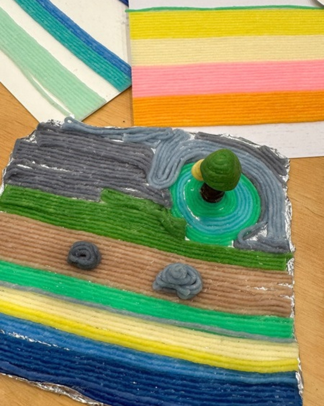 A whole island scene built entirely from colourful reusable wax sticks by a child at the workshop