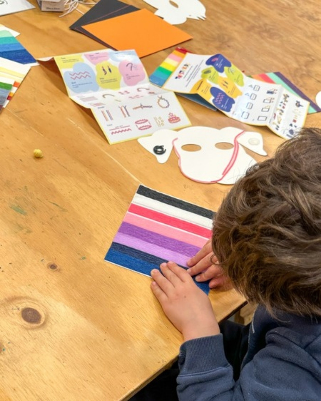Children decorating masks one twist at a time with colourful wax sticks