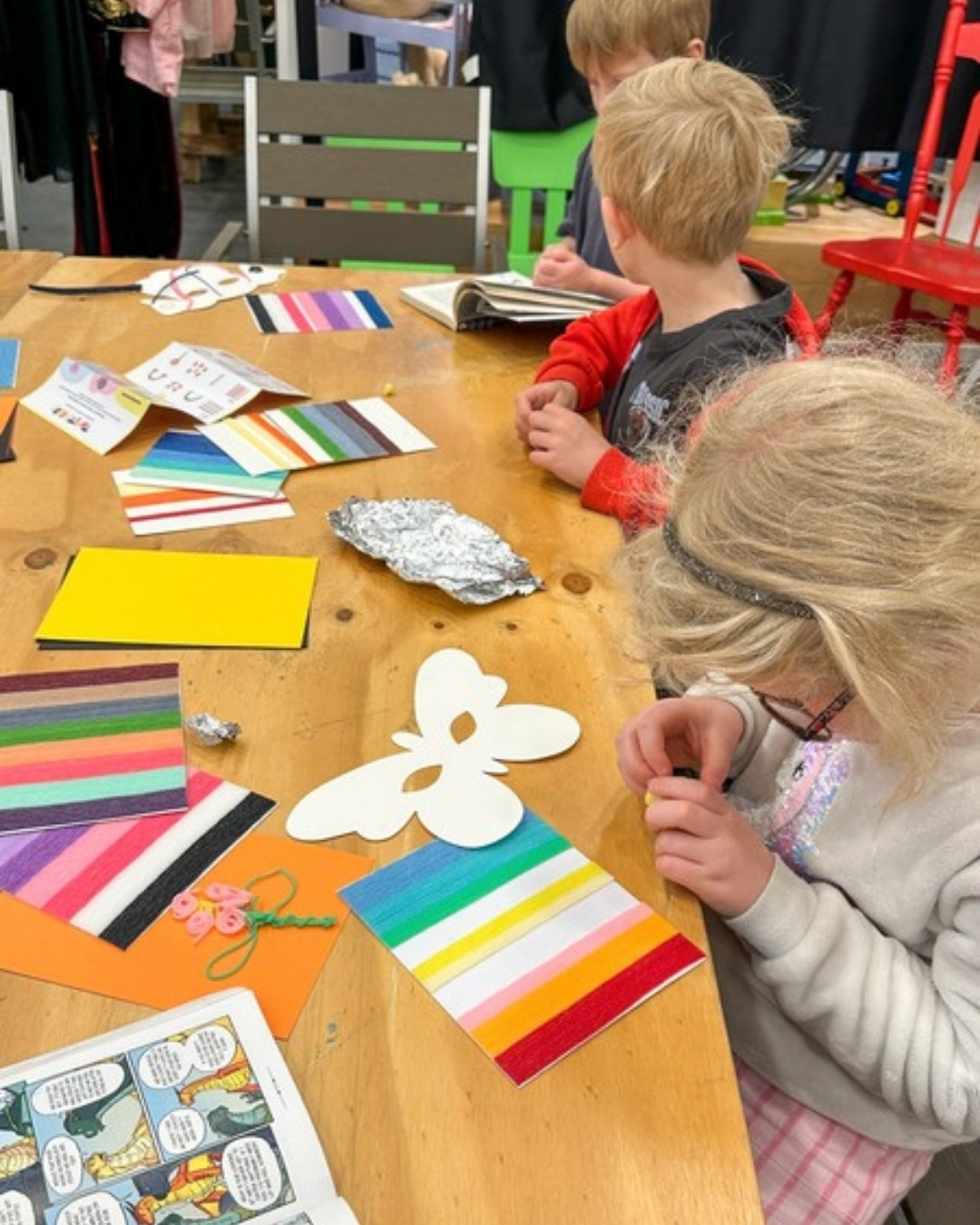 Children deeply focused and proud of their screen-free wax stick creations at the Twisty Kids workshop