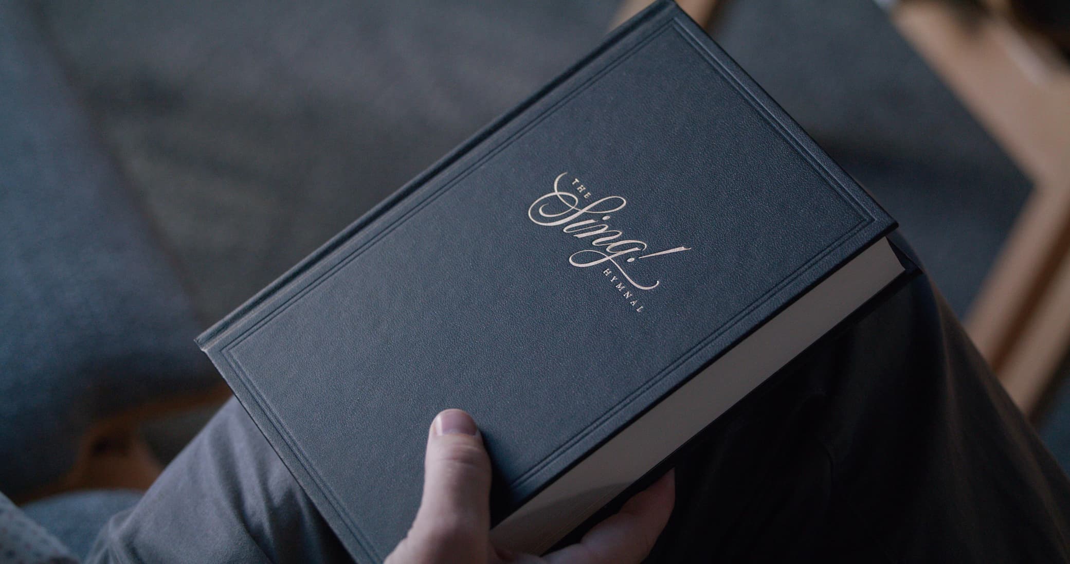 A father holding The Sing! Hymnal